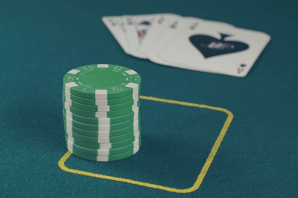 Chip kasino warna hijau tersusun rapi di atas meja