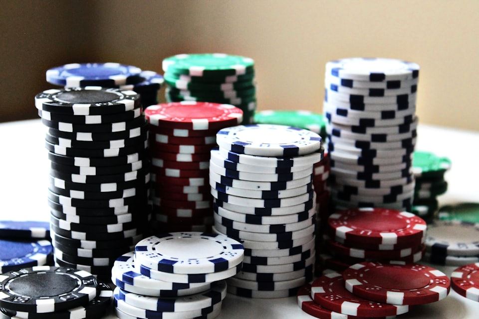 Tumpukan chip kasino berwarna-warni di atas meja